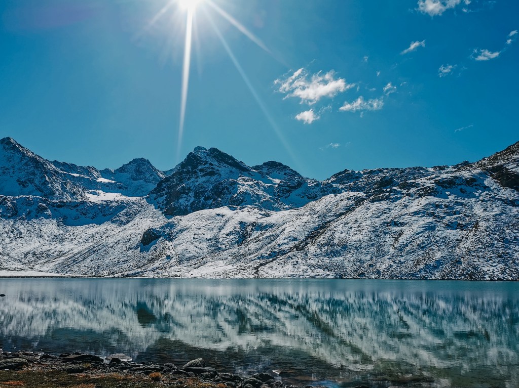 Zrkadlové jazero v ktorom sa odzažajú zasnežené kopce