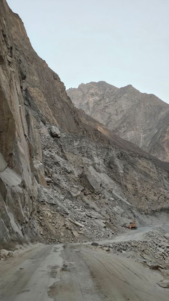 Spadnuté skaly na ceste v Tadžikistane. Báger ktorý spriechodňuje cestu.