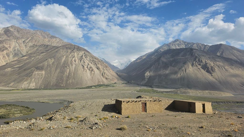 Hlineny, tehlový dom. modrá obloha, rieka.