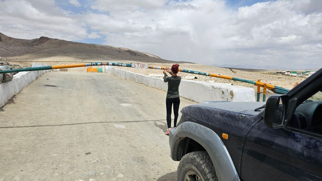 Vojeský checkpoint v pohraničnej zóne. Rampa cez cestu na ktorej sú nálepky.