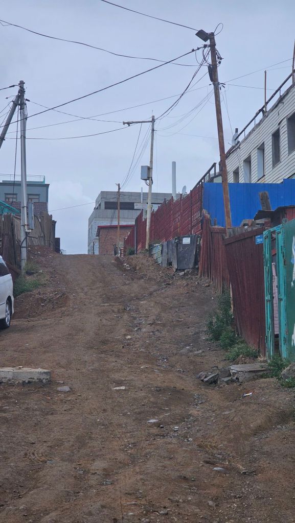 klasická ulica v centre, hlinená cesta, škaredý plechový hrdzavý plot