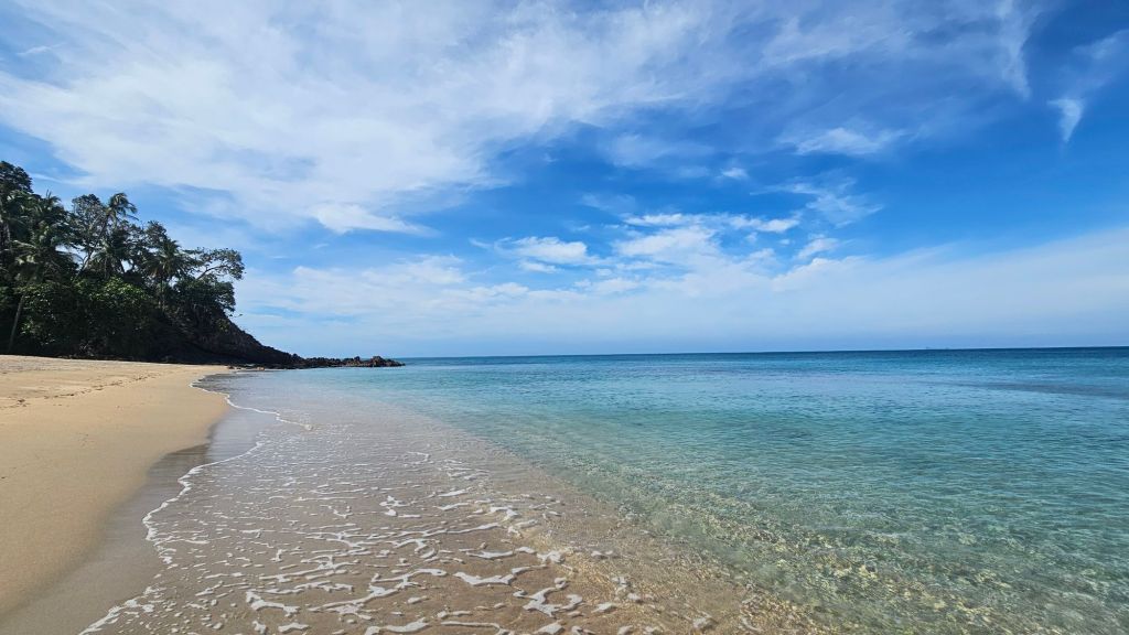 pláž, priehľadné čisté more a oblaky