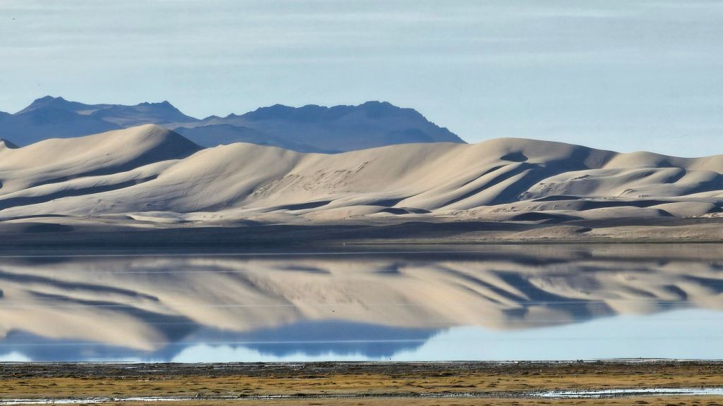 zrkadlové jazero v pozadí duny