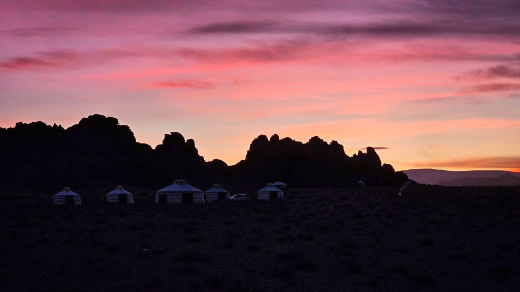 ružový západ slnka, skalné útvary a jurty v mongolsku