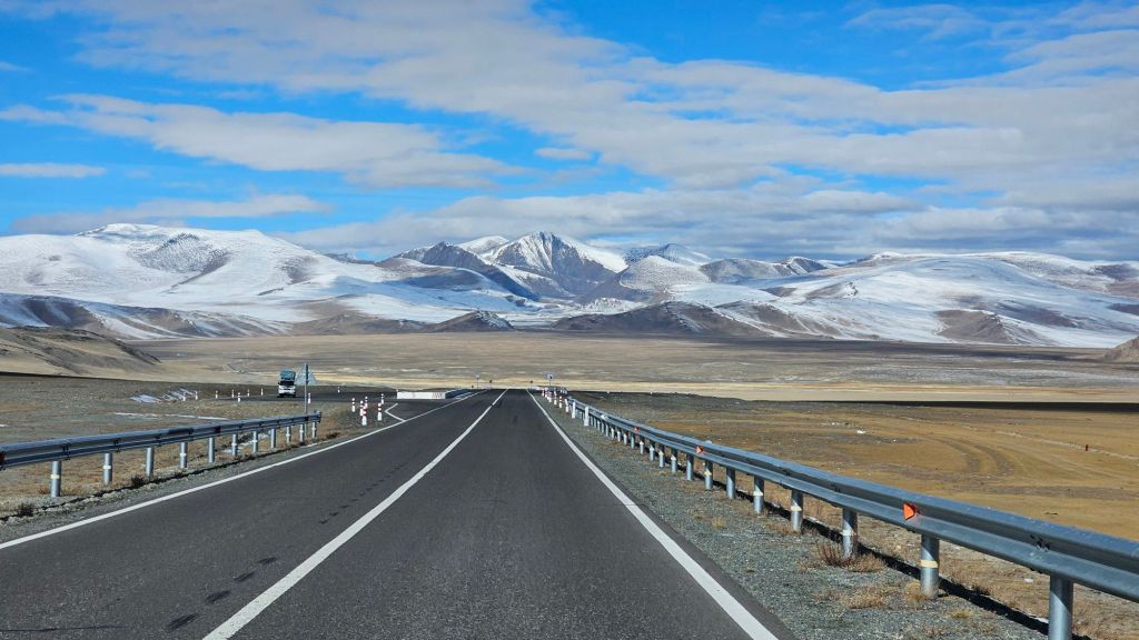 asfaltová cesta veduca cez hory ktoré su jemne zasnežené