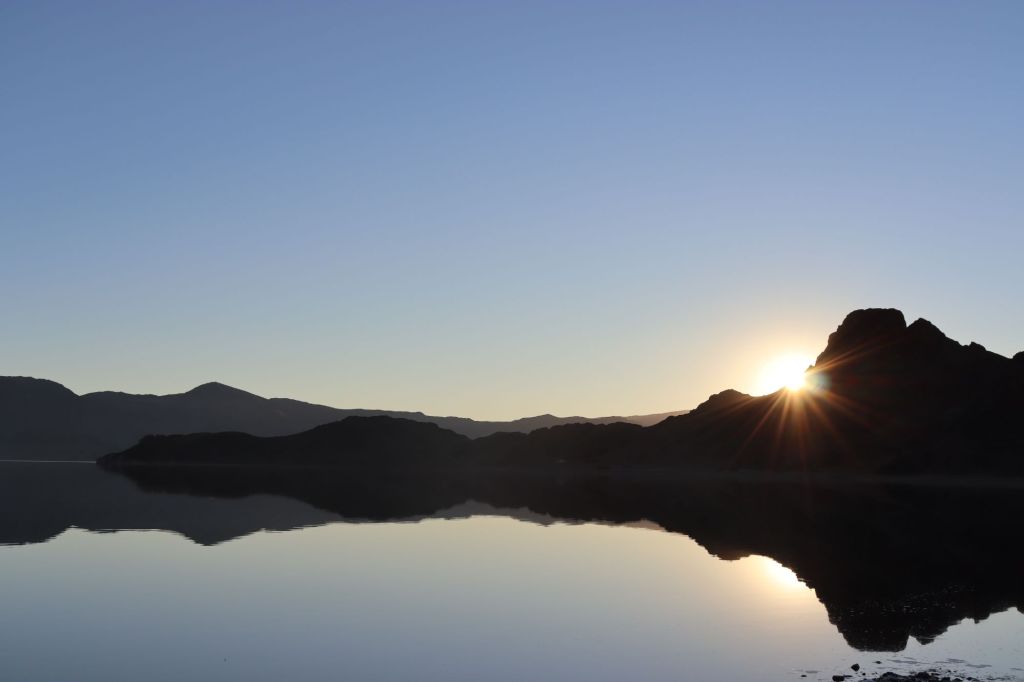 posledné lúče slnka ktoré zapadá za skaly
