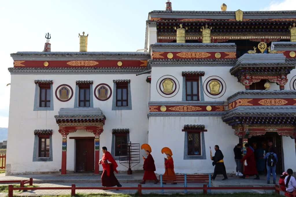 budhistický mnísi oblečený v tradičnom kráčajúci okolo chrámu 